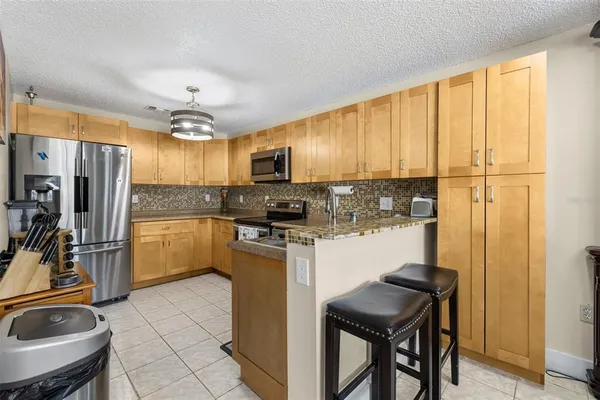 a kitchen with a refrigerator a sink and a stove top oven