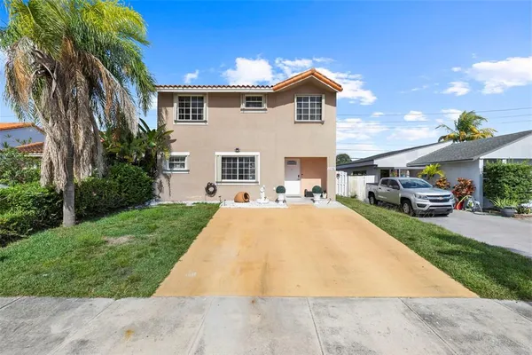 a front view of a house with a garden and patio