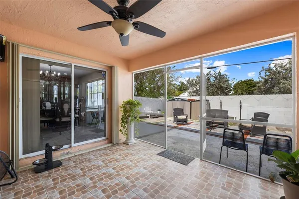 a living room with patio furniture and a floor to ceiling window