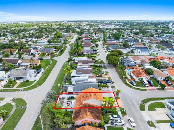 an aerial view of residential houses with outdoor space and swimming pool