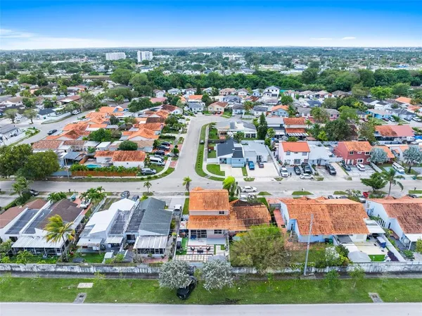 an aerial view of residential houses with outdoor space and swimming pool
