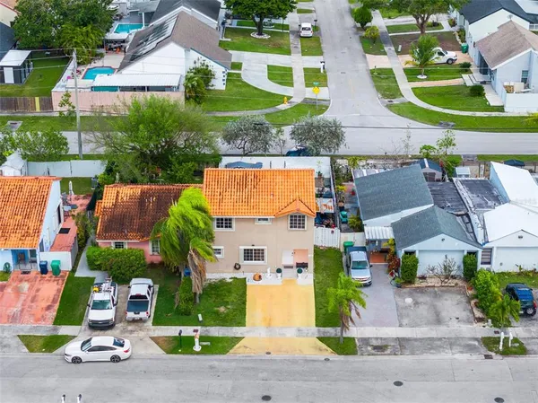 an aerial view of residential houses with outdoor space and street view