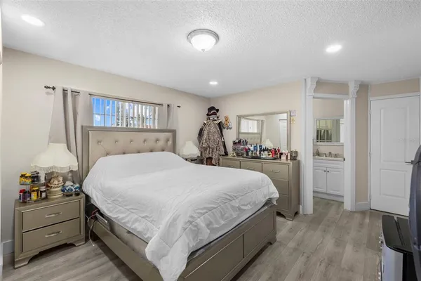 a bedroom with a large bed and a chandelier