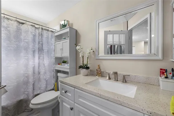 a bathroom with a granite countertop sink toilet and shower