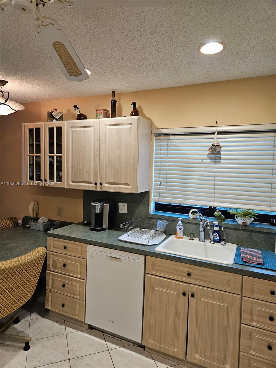 10301 Greenbriar Court Boca Raton, FL 33498 - Photo 21 of 43 a kitchen with granite countertop a sink a stove a dining table and chairs