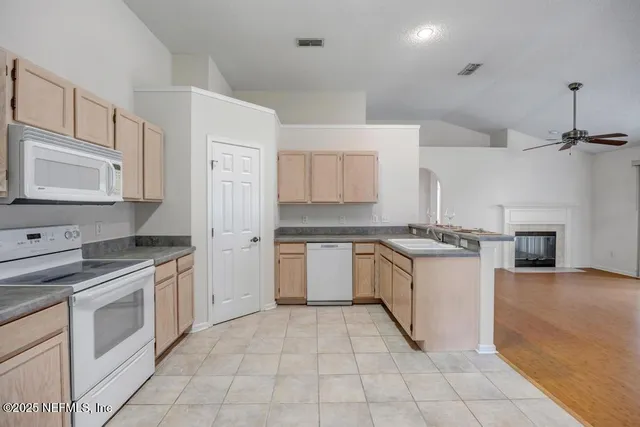 a kitchen with granite countertop a sink stove and cabinets