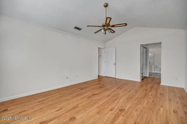 a view of empty room with wooden floor