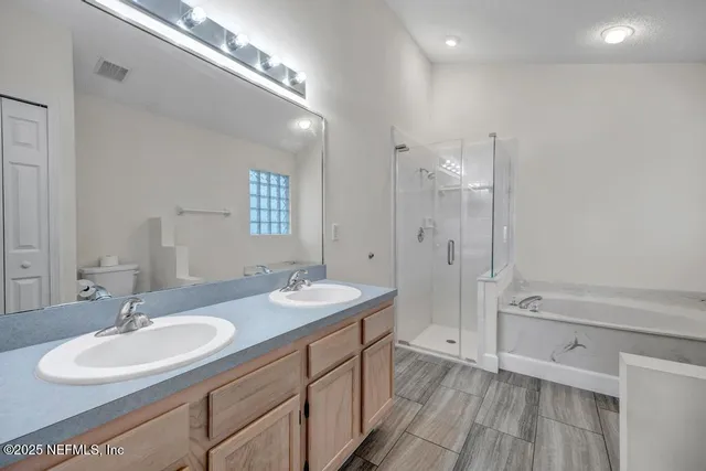 a spacious bathroom with a double vanity sink double mirror and bathtub