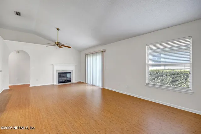 a view of an empty room with a fireplace and a window