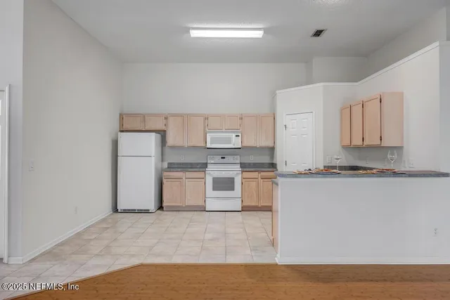a kitchen with stainless steel appliances granite countertop a stove a sink and white cabinets