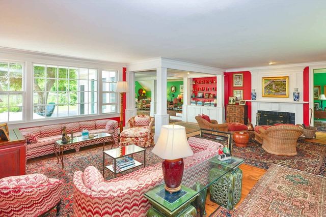 a living room with fireplace furniture and a large window
