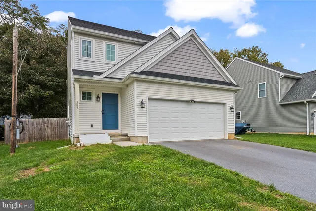 a front view of a house with a garden and yard