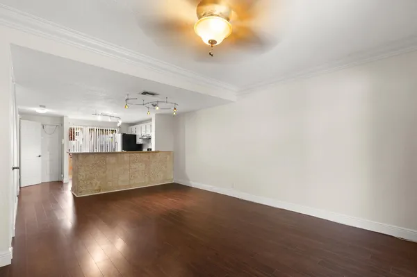a view of a room with wooden floor and a ceiling fan