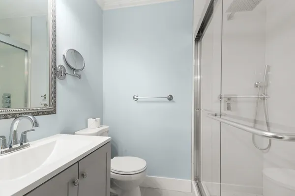 a bathroom with a granite countertop sink toilet and shower