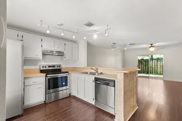 a kitchen with stainless steel appliances granite countertop a stove cabinets and wooden floor