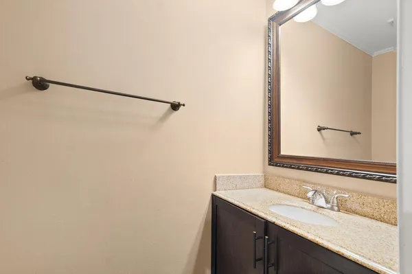 a bathroom with a granite countertop sink and a mirror