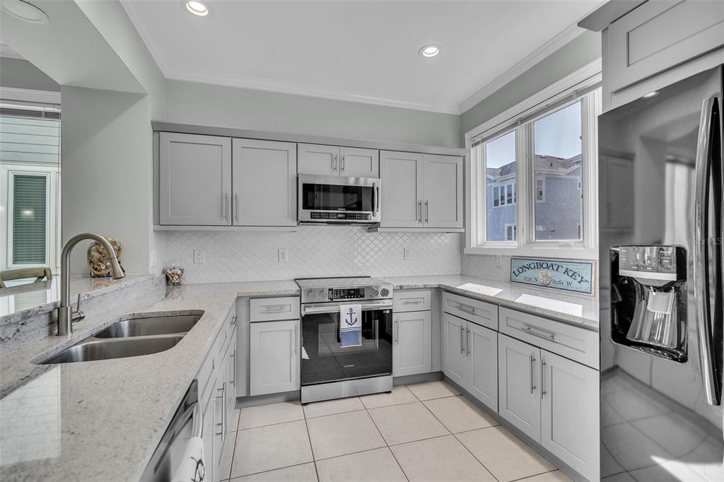 848 Evergreen Way Longboat Key, FL 34228 - Photo 10 of 66 a kitchen with white cabinets and appliances
