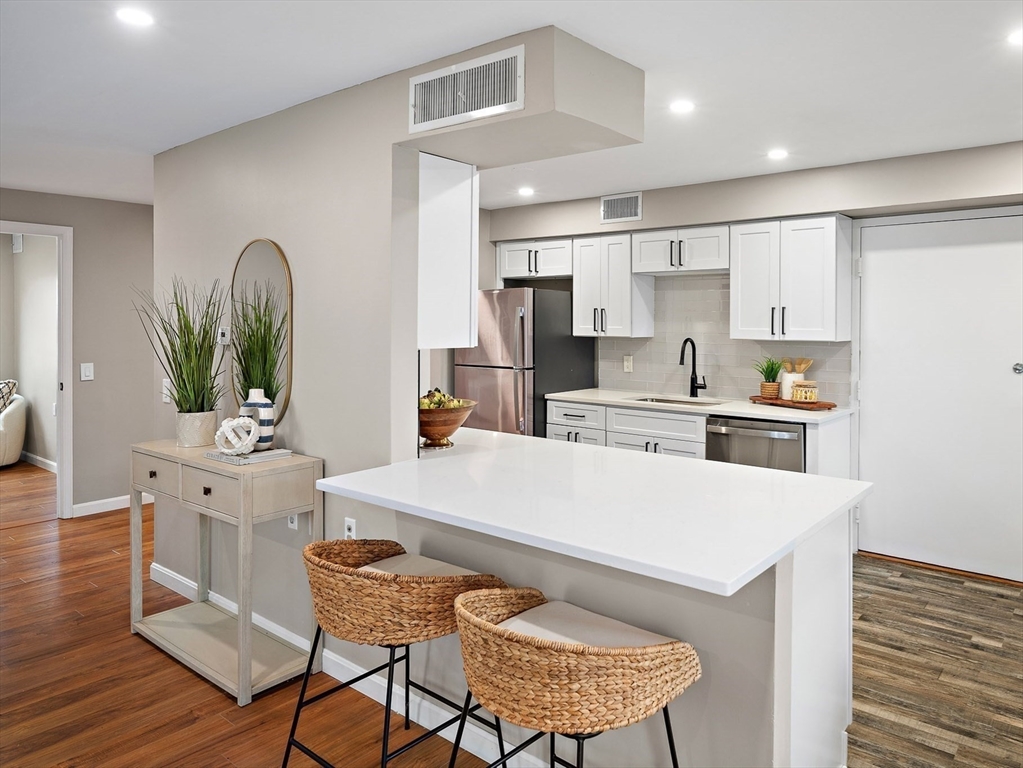 6 Beal's Cove Road, Unit H Hingham, MA 02043 - Photo 1 of 15 a kitchen with a table chairs and a refrigerator