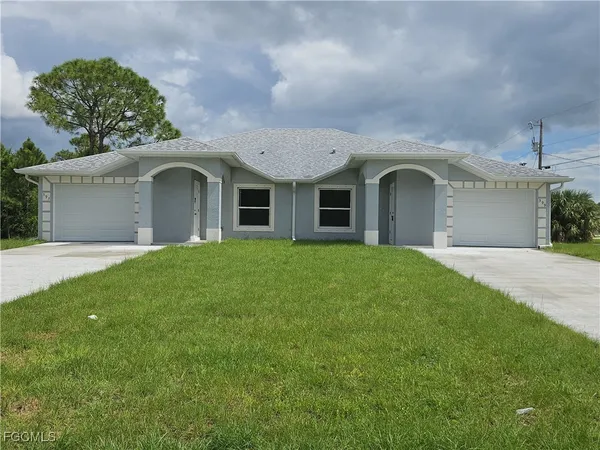 a front view of a house with yard and green space