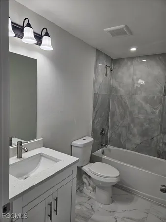 a bathroom with a toilet a sink and mirror