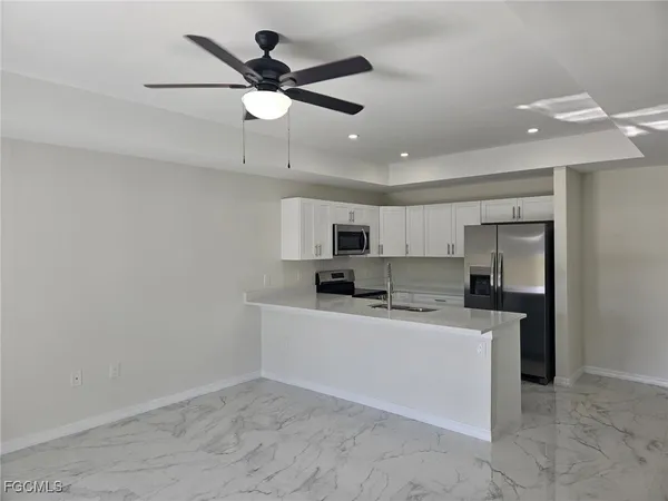 a kitchen with kitchen island a sink stainless steel appliances and counter space
