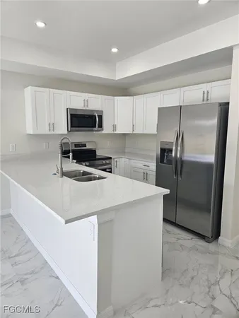 a kitchen with stainless steel appliances a refrigerator sink and microwave