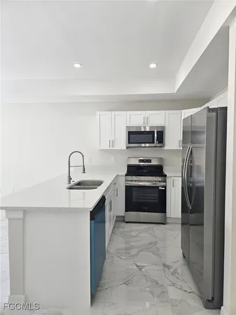 a kitchen with stainless steel appliances a refrigerator stove and sink