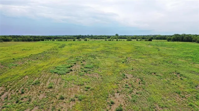 a view of a green field with a building in the background