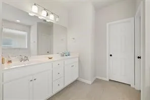 a spacious bathroom with double sink and a mirror