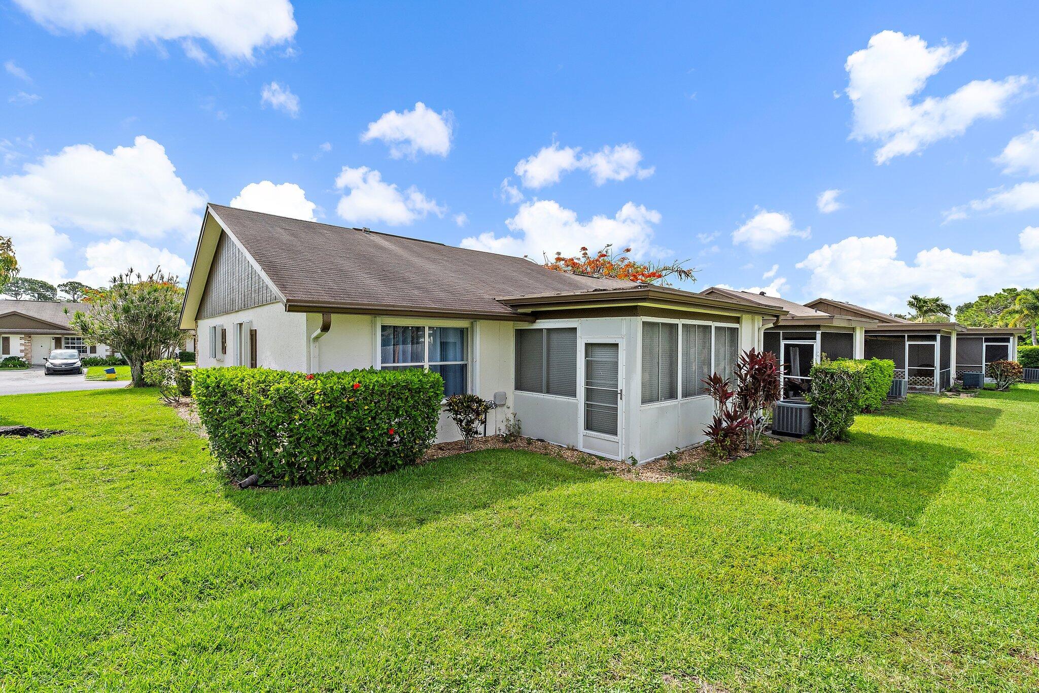 109 Doe Trail Jupiter, FL 33458 - Photo 24 of 26 a front view of a house with a garden and porch