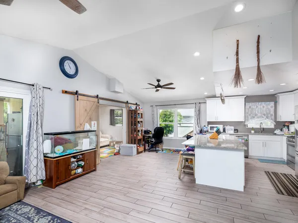 a kitchen view with stainless steel appliances wooden floor and large windows