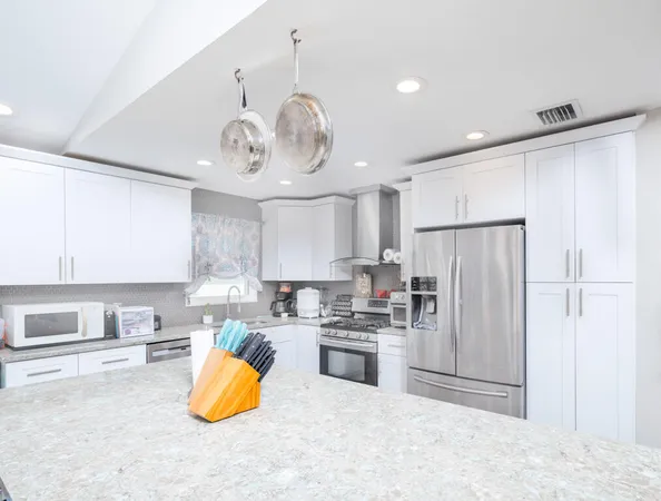 a kitchen with stainless steel appliances granite countertop a refrigerator a stove a sink and a refrigerator