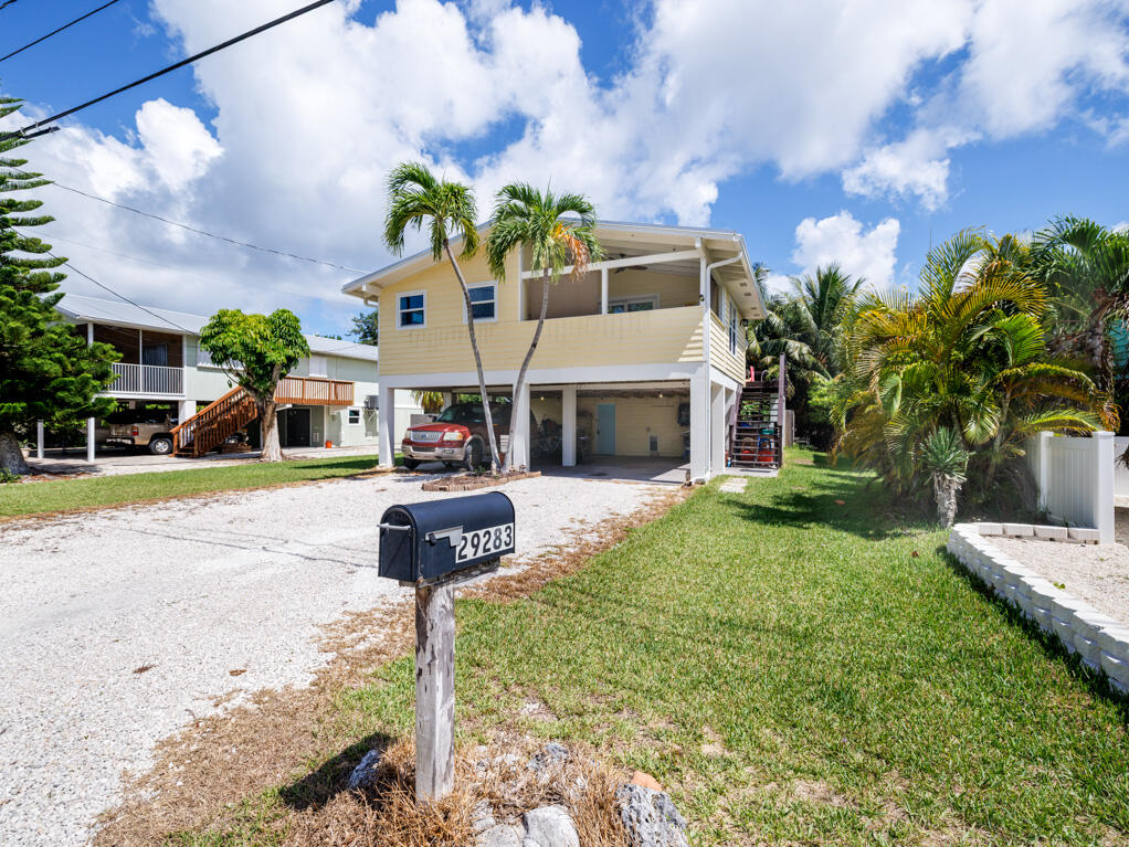 29283 Coconut Palm Drive Big Pine Key, FL 33043 - Photo 2 of 35 a front view of a house with a yard and potted plants