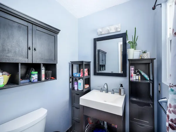 a bathroom with a sink a toilet and a mirror