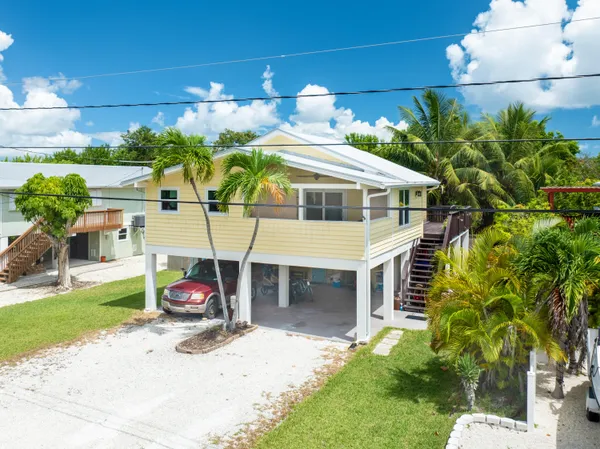a view of a house with a yard and patio