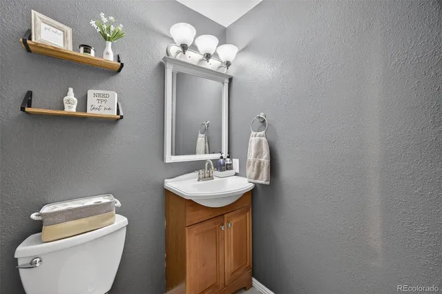 a bathroom with a toilet a sink and mirror