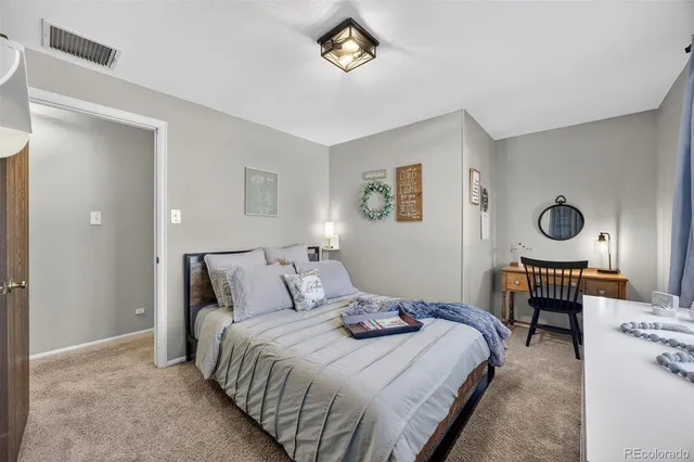 a bedroom with a bed and a dresser with rug