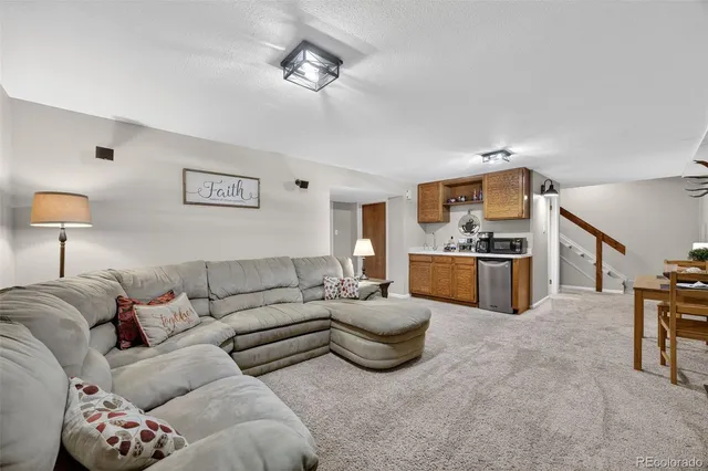 a living room with furniture and kitchen