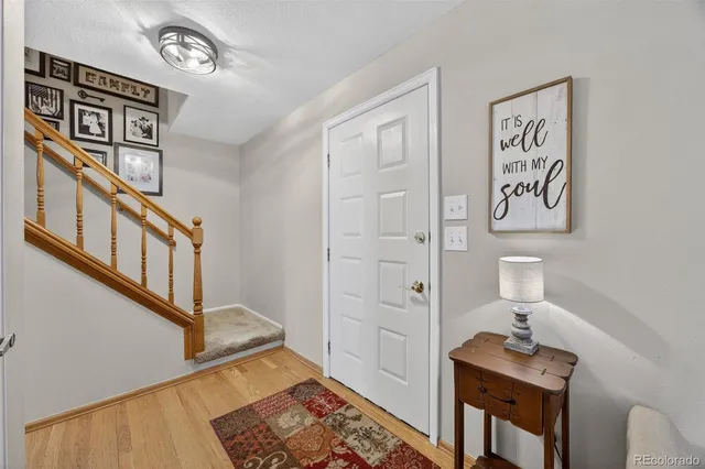 a view of a hallway with wooden floor and staircase