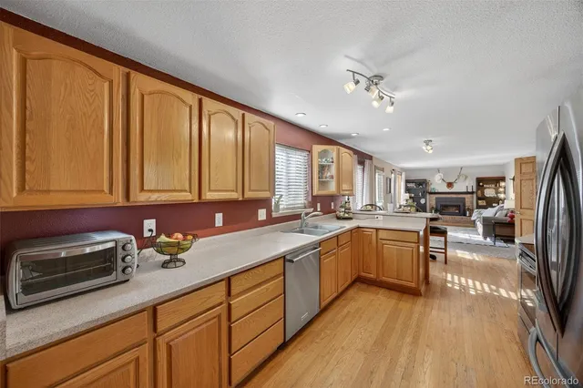 a kitchen with stainless steel appliances granite countertop sink stove refrigerator and cabinets