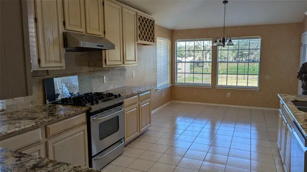 a kitchen with granite countertop a stove and a sink