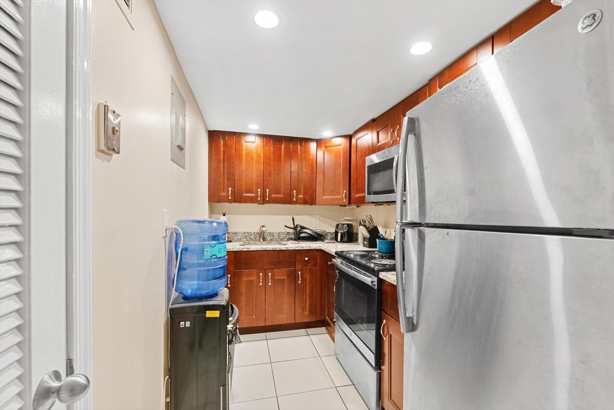 200 South Birch Road, Unit 204 Fort Lauderdale, FL 33316 - Photo 6 of 21 a kitchen with granite countertop a refrigerator a sink a stove and cabinets