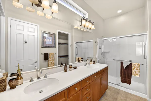 a bathroom with a double vanity sink a mirror and a shower