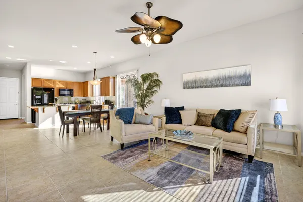 a living room with furniture kitchen view and a chandelier