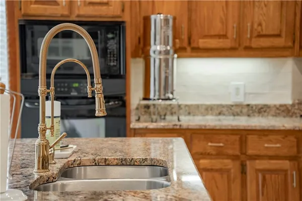 a kitchen with granite countertop a sink and a refrigerator