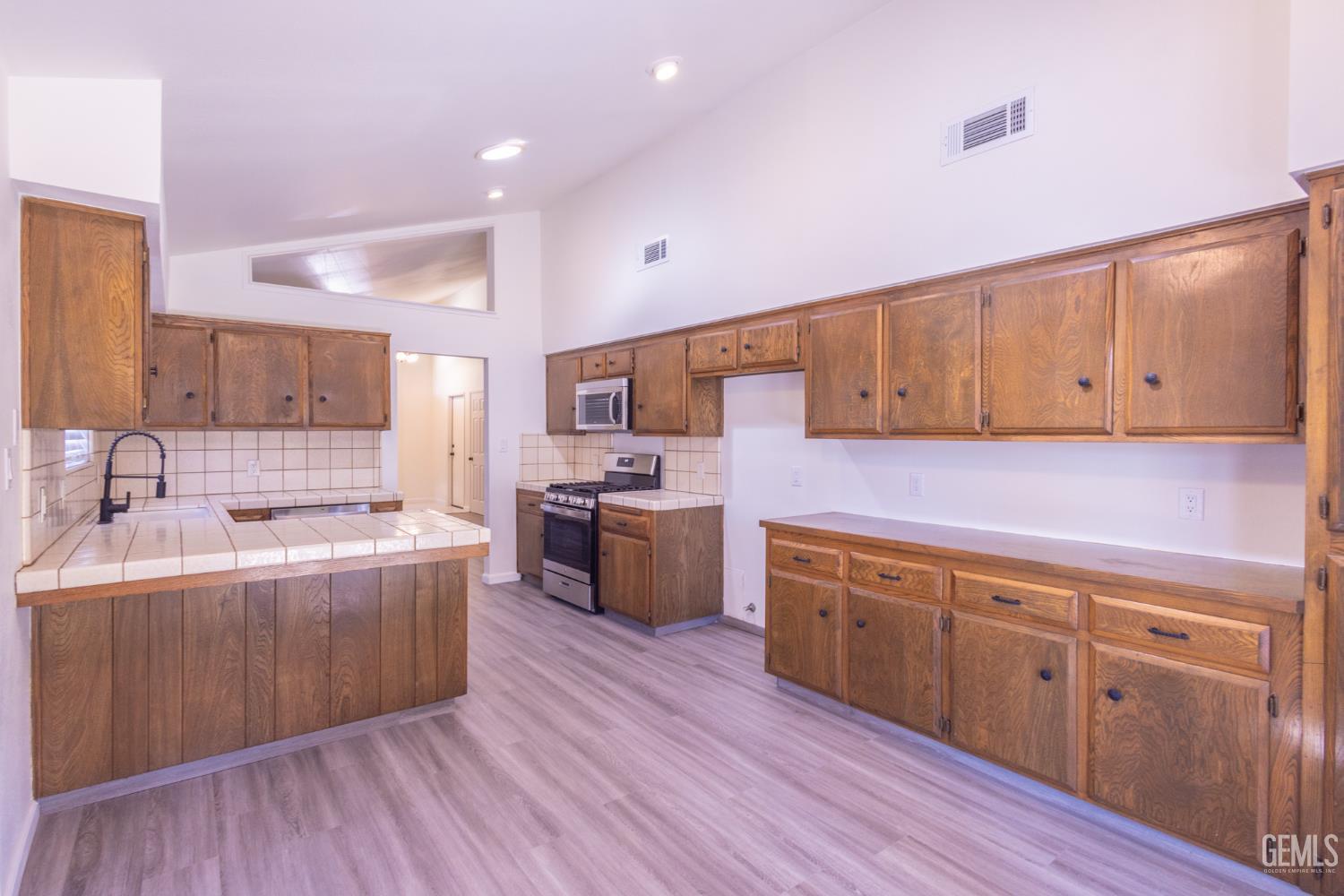 Undisclosed Address Bakersfield, CA 93309 - Photo 12 of 37 a kitchen with stainless steel appliances sink cabinets and wooden floor