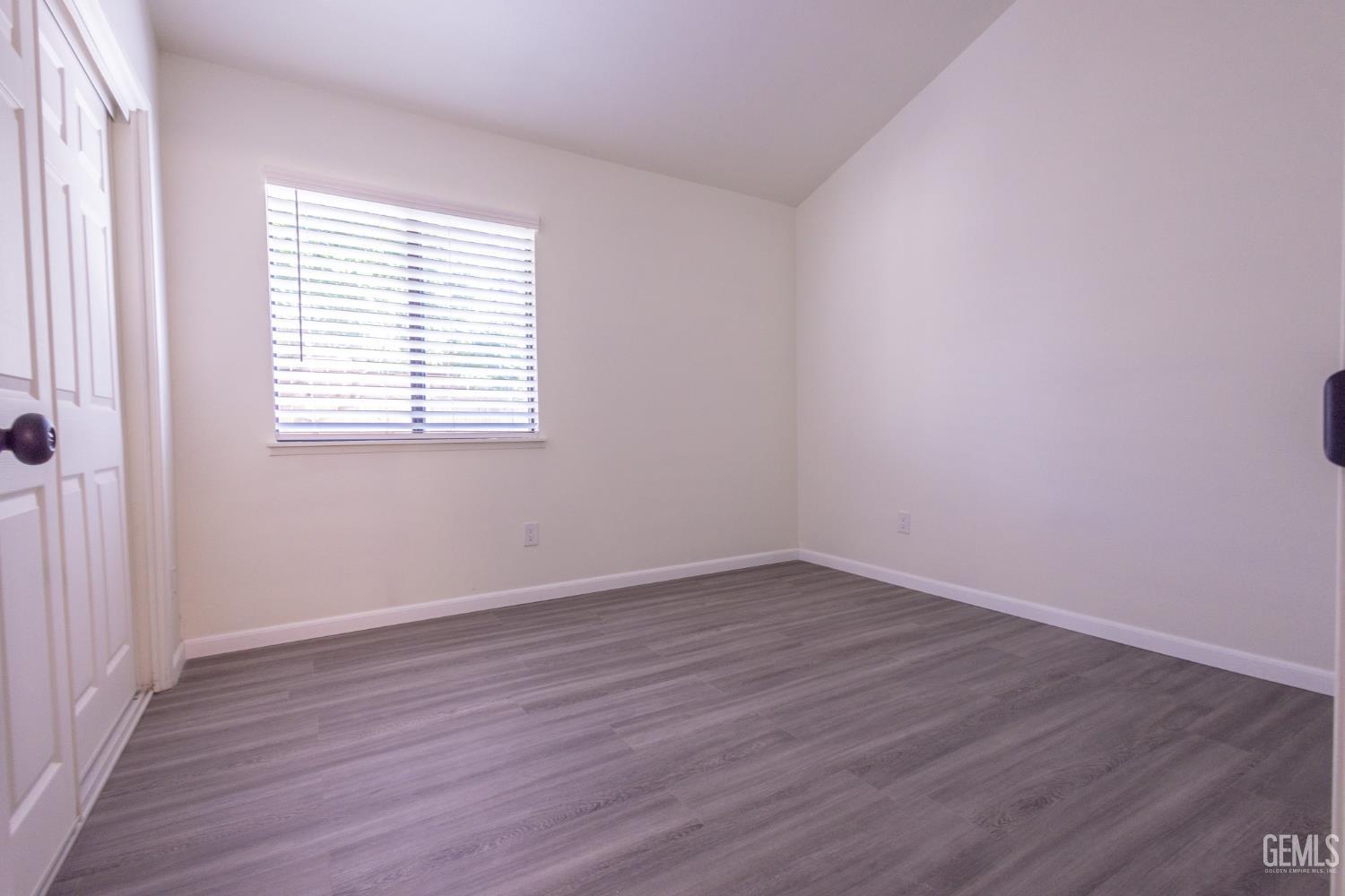 Undisclosed Address Bakersfield, CA 93309 - Photo 17 of 37 an empty room with wooden floor and windows
