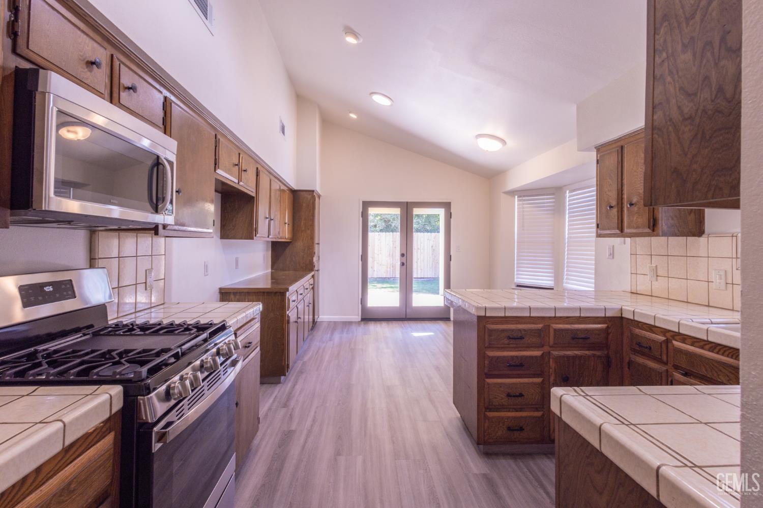 Undisclosed Address Bakersfield, CA 93309 - Photo 10 of 37 a kitchen with stainless steel appliances and wooden cabinets