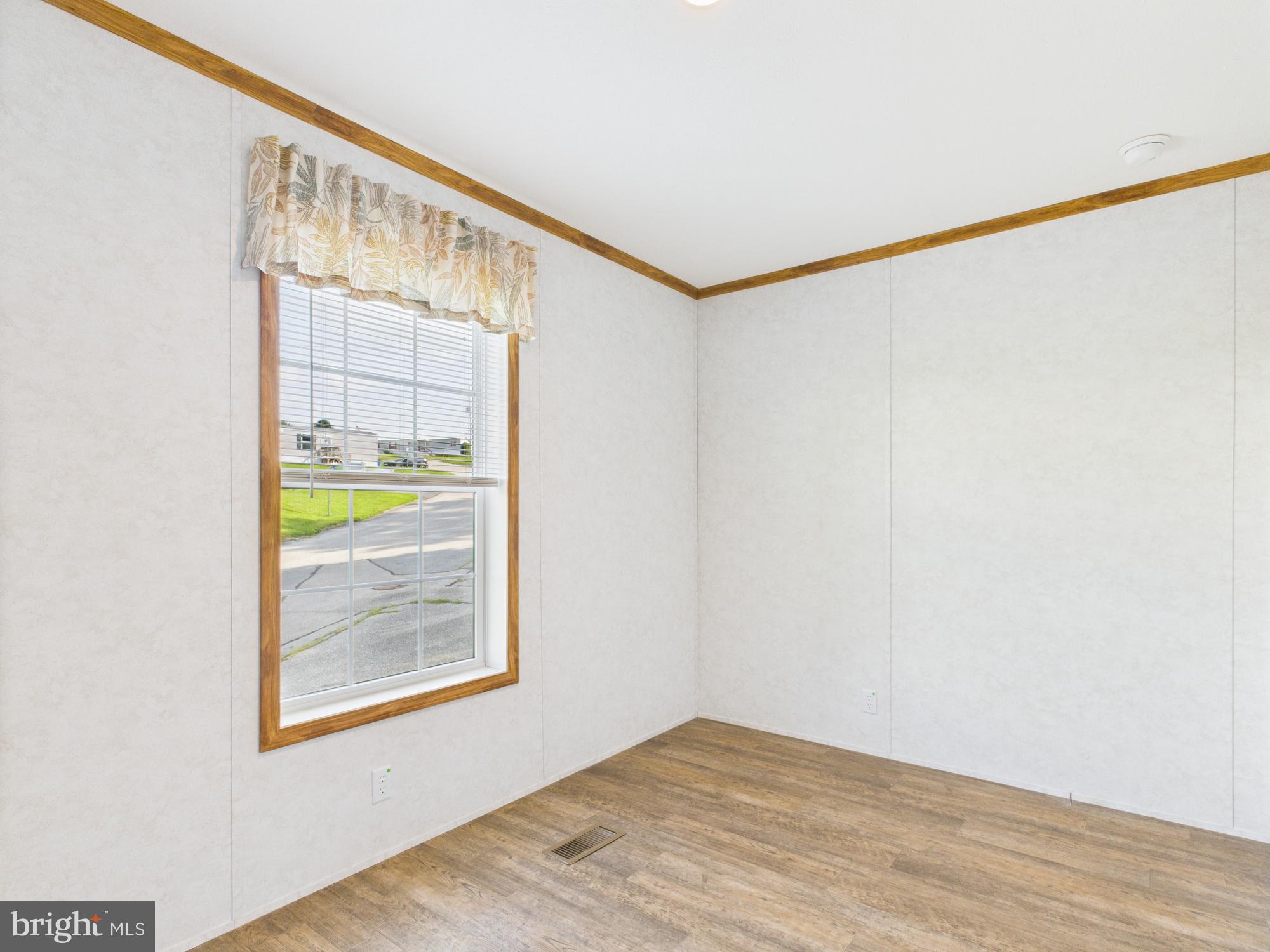 140 Rustique Drive York, PA 17408 - Photo 22 of 25 a view of an empty room with a window and wooden floor