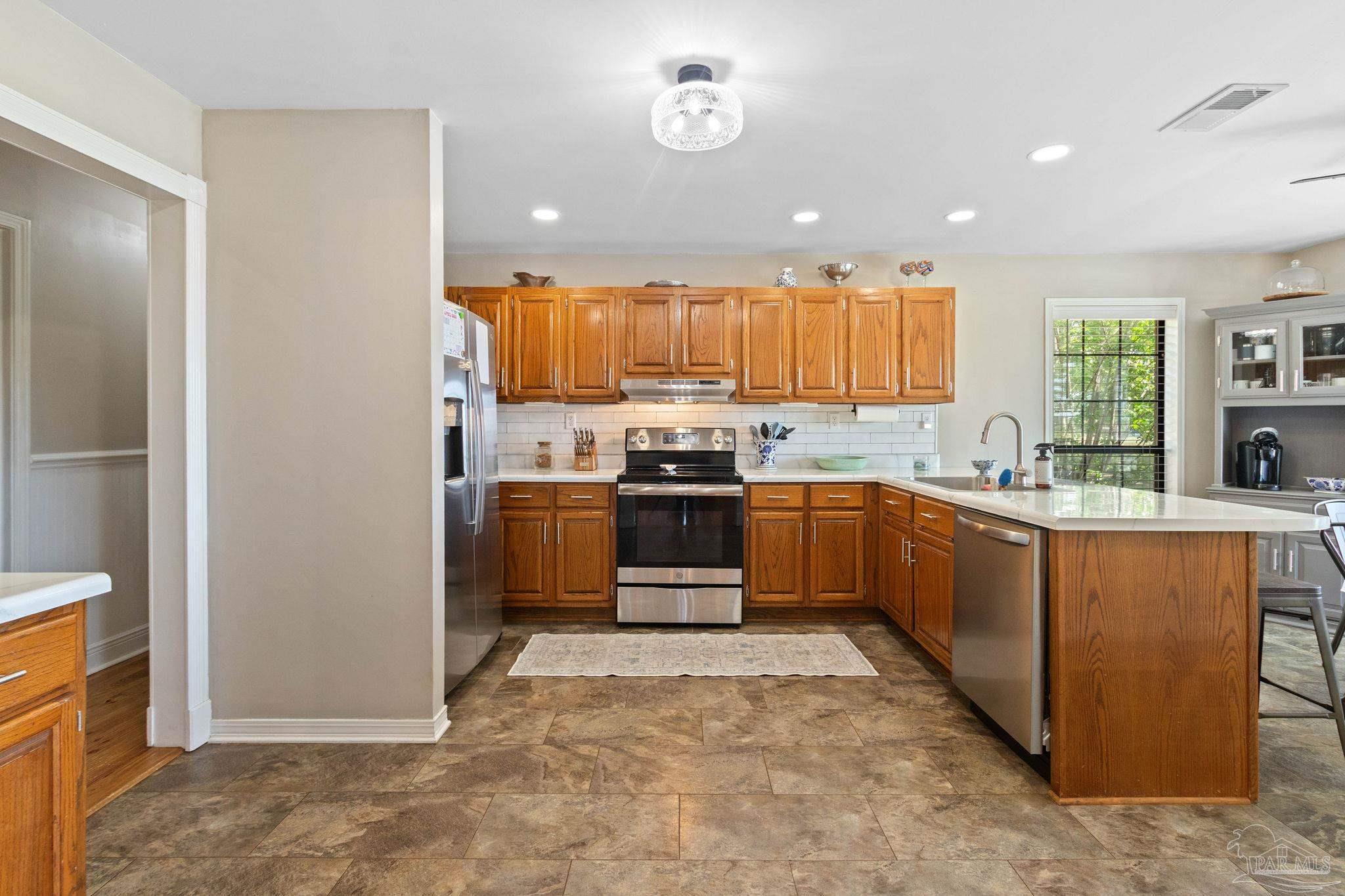 4349 Turkey Hollow Road Frisco City, AL 36445 - Photo 17 of 64 a kitchen with stainless steel appliances granite countertop a stove a sink and a refrigerator